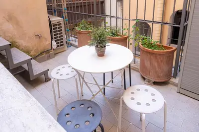 a white table and chairs on a balcony with plants at Domus Loft Colosseum - Rione Monti in Rome