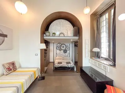 a bedroom with a bed and a table and a window at Domus Loft Colosseum - Rione Monti in Rome