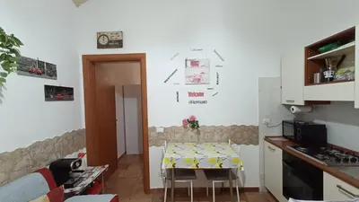 a small kitchen with a table and a table and a room at Little House Roma in Rome