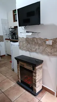 a living room with a fireplace with a tv above it at Little House Roma in Rome