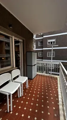 a balcony with chairs and a refrigerator on a building at Bella Roma Stay in Rome