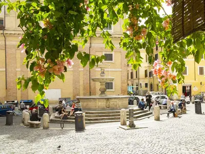 people sitting around a fountain in front of a building at Luxury Suite Monti Quirinale in Rome