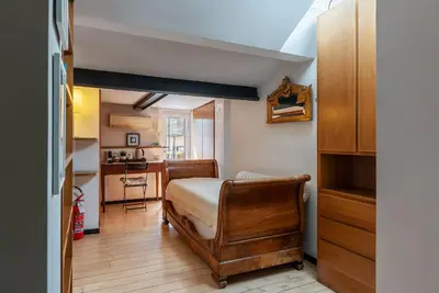 a small bedroom with a bed and a kitchen at Orange Room with bathroom and Shared Terrace in Rome