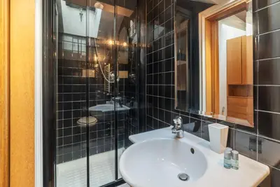 a bathroom with a sink and a glass shower at Orange Room with bathroom and Shared Terrace in Rome