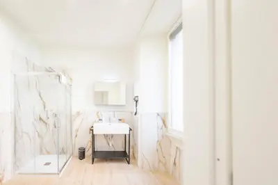 a white bathroom with a sink and a mirror at Domus Giulio Guest House in Rome