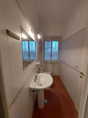 a white bathroom with a sink and a mirror at La Casa Dei Nonni al Vaticano in Rome