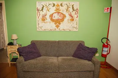 a living room with a couch and a painting on the wall at La Casetta del '32 in Rome