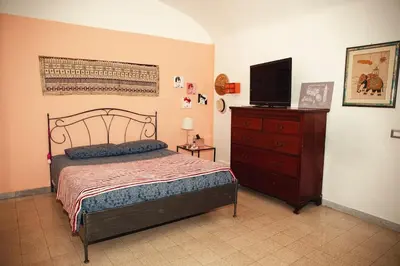 a bedroom with a bed and a dresser with a television at La Casetta del '32 in Rome