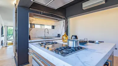 a kitchen with a stove top oven next to a counter at EasyTopStay - Rome from above Apt with a view in Rome