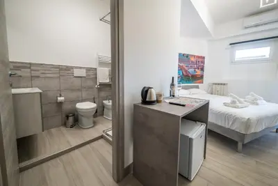 a small bedroom with a bed and a bathroom at Domus Garbatella in Rome