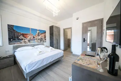 a white bedroom with a bed and a table at Domus Garbatella in Rome