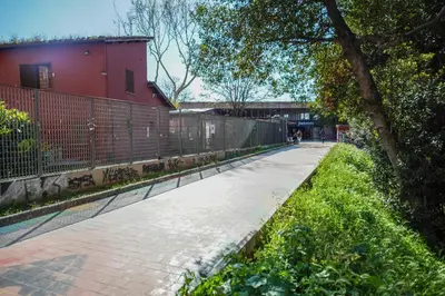 a sidewalk next to a red building with a fence at Domus Garbatella in Rome