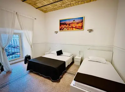 a bedroom with two beds and a painting on the wall at Roma Comfort Inn in Rome