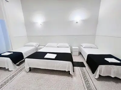 three beds in a room with white walls at Roma Comfort Inn in Rome