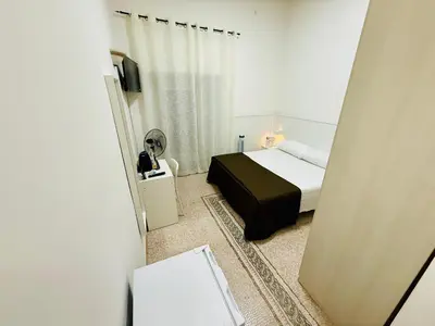 a small bedroom with a bed and a mirror at Roma Comfort Inn in Rome