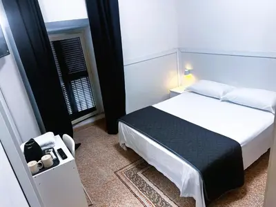a bedroom with a white bed and a window at Roma Comfort Inn in Rome