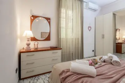 a bedroom with a bed with a dresser and a mirror at RomAntica Laterano in Rome