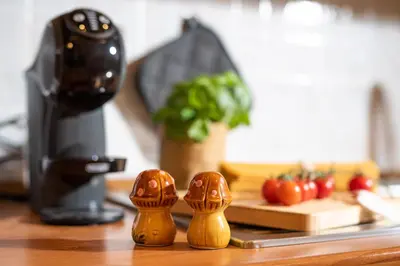 two wooden figurines on a counter next to a juicer at RomAntica Laterano in Rome