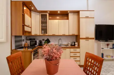 a kitchen with a table with a vase of flowers on it at RomAntica Laterano in Rome