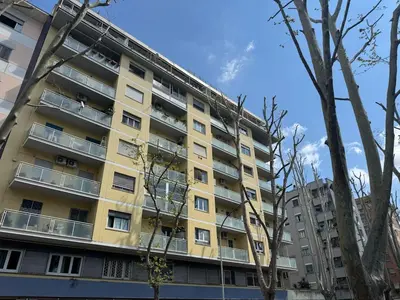 a yellow apartment building with trees in the foreground at Studio in the Green Roma in Rome