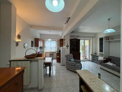 a kitchen and a living room with a table at Studio in the Green Roma in Rome