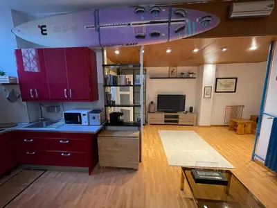a kitchen with purple cabinets and a living room at AT Simone Cavallini in Rome