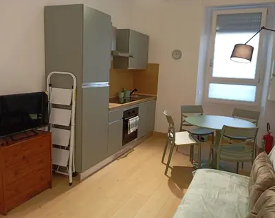 a small kitchen with a table and a dining room at Grazioso e moderno nuovo appartamento in Rome
