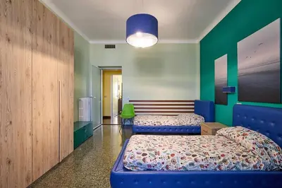 a bedroom with two beds and a green wall at Casa Tembien in Rome in Rome