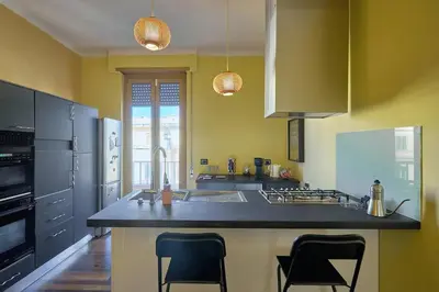 a kitchen with yellow walls and a counter with chairs at Casa Tembien in Rome in Rome