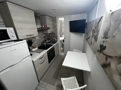 a kitchen with a white refrigerator and a white table at Machiavelli's House in Rome