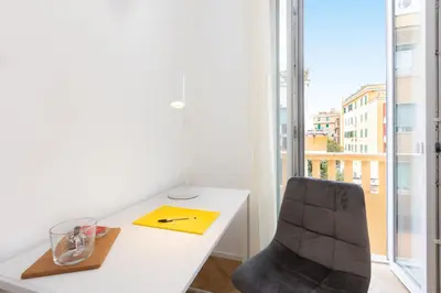 a white desk and a chair in a room with a window at Amazing Monteverde in Rome
