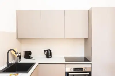 a kitchen with white cabinets and a sink at Amazing Monteverde in Rome