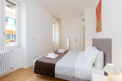 a white bedroom with a bed and a window at Amazing Monteverde in Rome