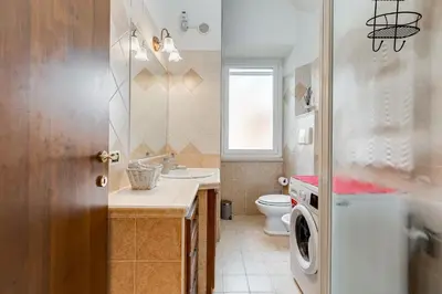 a bathroom with a toilet sink and a washing machine at Villa Riccio-Flaminio House in Rome