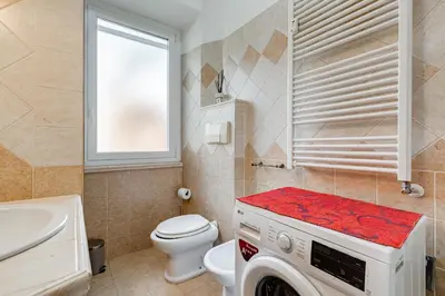 a bathroom with a washer and a toilet and a sink at Villa Riccio-Flaminio House in Rome