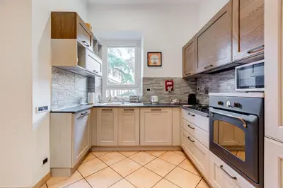 a kitchen with wooden cabinets and a stove at Villa Riccio-Flaminio House in Rome