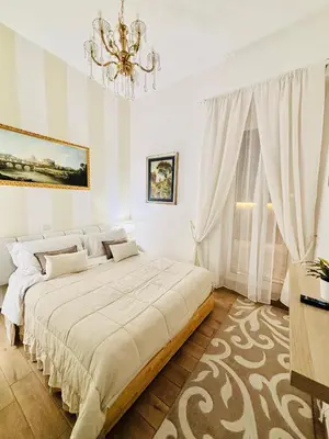 a white bedroom with a large bed and a chandelier at Mami Garden in Rome