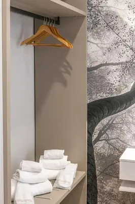 a bathroom with towels on a shelf with a tree mural at Guest House Colosseo Terrestre in Rome