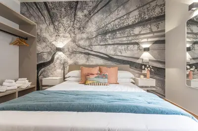 a bedroom with a bed with a wall mural at Guest House Colosseo Terrestre in Rome