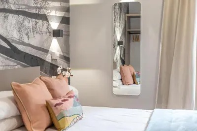 a bedroom with a bed with a mirror on the wall at Guest House Colosseo Terrestre in Rome