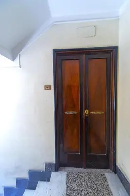 a wooden door in a building with blue steps at Clodia Holiday Home in Rome