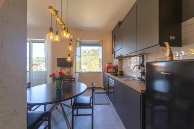a kitchen with a table and a dining room at Clodia Holiday Home in Rome