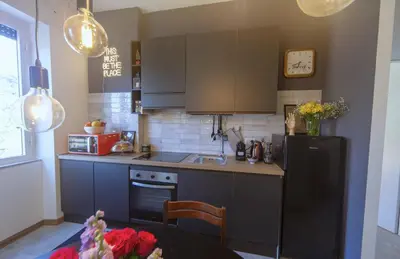a kitchen with a black refrigerator and a table at Clodia Holiday Home in Rome