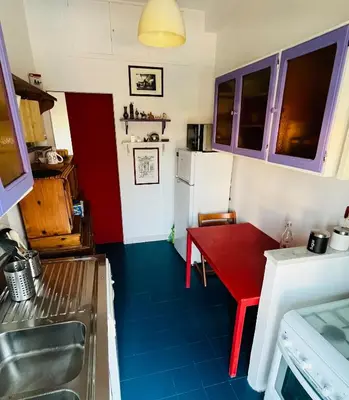 a kitchen with a red table and a refrigerator at Pinuz Guest House in Rome