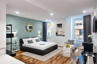 a bedroom with a large white bed and a chair at Piazza di spagna 32 Fellini Design Suites in Rome