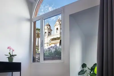 a window with a view of a church at Piazza di spagna 32 Fellini Design Suites in Rome