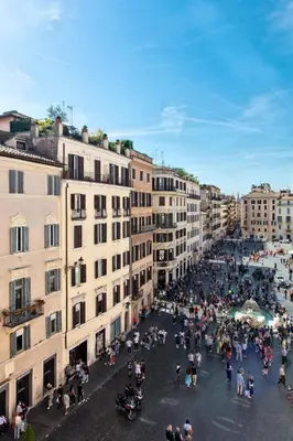a group of people sitting on a street in a city at Piazza di spagna 32 Fellini Design Suites in Rome