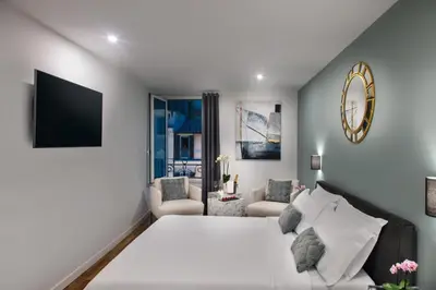 a bedroom with a large white bed and a living room at Piazza di spagna 32 Fellini Design Suites in Rome