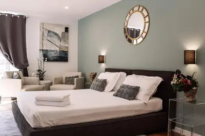 a bedroom with a large bed and a living room at Piazza di spagna 32 Fellini Design Suites in Rome