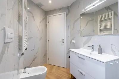 a white bathroom with a sink and a mirror at BMGA l Poppy's Home Attic Vaticano in Rome